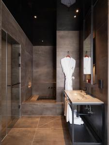 a bathroom with a sink and a shower and a tub at The Moor in Busan