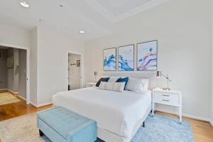 una camera da letto bianca con un letto grande e uno sgabello blu di Central DC Retreat Luxury In-Law Suite 3BR & 3 BA #DCottage a Washington
