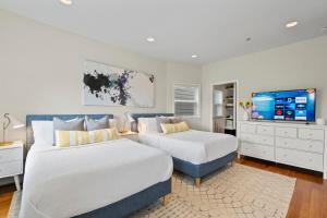 una camera da letto con due letti e una TV a schermo piatto di Central DC Retreat Luxury In-Law Suite 3BR & 3 BA #DCottage a Washington