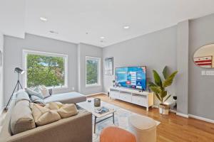un soggiorno con un divano e una TV di Central DC Retreat Luxury In-Law Suite 3BR & 3 BA #DCottage a Washington