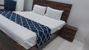 a bedroom with a bed with a blue and white comforter at Karachi Guest House University Rd in Karachi +8 photos