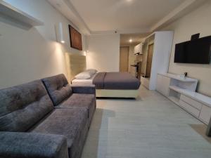 a living room with a couch and a bed at Studio Room Apartment with Pool in Yogyakarta