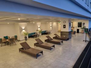 an empty lobby with chairs and tables and chairs at Studio Room Apartment with Pool in Yogyakarta