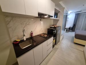 a kitchen with a sink and a counter top at Studio Room Apartment with Pool in Yogyakarta