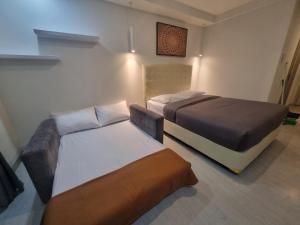 a room with two beds and a couch in it at Studio Room Apartment with Pool in Yogyakarta +14 photos