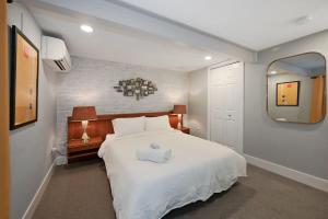 a bedroom with a large white bed and a mirror at Cozy Mid-Century Apartment Steps From Restaurants #DCottage in Washington