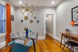 a dining room with a glass table and blue chairs at Mid-Century Marvel Steps from Restaurants Bars and Markets 3BR & 2BA in Washington