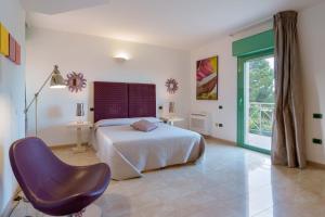 Un dormitorio con una cama y una silla dentro. en Villa Ferrara Sardegna, en Capoterra