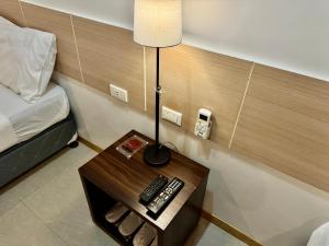 a lamp on a table next to a bed at Soi Suites in Talibon
