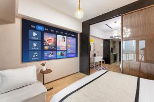 sypialnia z łóżkiem i dużym ekranem w obiekcie Manriver Executive Apartments w Guangzhou