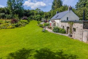 eine Luftaufnahme eines Steinhauses mit einem grünen Hof in der Unterkunft Pwll Cottage in Carmarthen