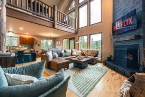 a living room with couches and a fireplace at Whispering Pine Chalet - HotTub, Sauna, StargazingNet in Fairplay