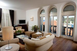a living room with a couch and chairs and windows at Villa Hvar Royale - 5 Bedroom Central Villa - Indoor Pool - Beautiful Heritage Villa in Hvar