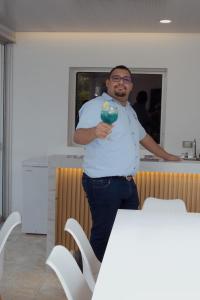 un uomo in piedi al bancone con in mano un drink di Hotel Daniels a Fonseca