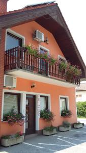 a building with a balcony with flowers on it at Bed and Breakfast Kreft in Ljutomer
