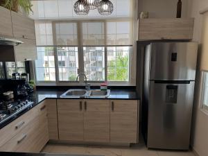 a kitchen with a stainless steel refrigerator and a sink at 3E- Condominio exclusivo con alberca in Manzanillo