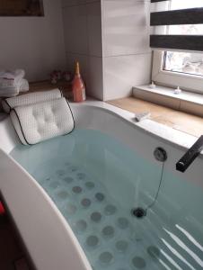 a bath tub in a bathroom with a window at Apartment romantyczny SAKURA in Jędrzejów +9 photos
