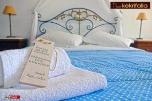 a bed with towels and a sign on it at Kekrifalia Hotel in Skala