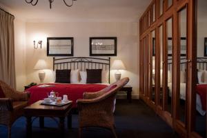 une chambre d'hôtel avec un lit, une table et des chaises dans l'établissement Melrose Place, à Johannesbourg