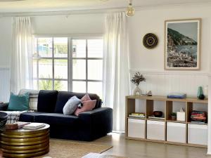 a living room with a black couch and a window at ROBE TWO FIVE - Pet friendly outside WiFi in Robe