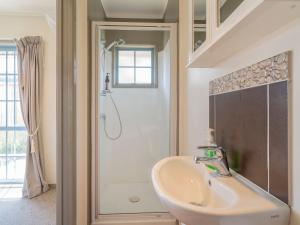 un baño con lavabo y ducha en Charming Family Retreat - Cozy 3 Bedroom & 3 Bathroom, en Whitianga 4 fotos más