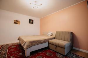 a small bedroom with a bed and a chair at Casa Ilinca in Filioara
