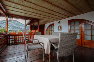 a porch with a table and chairs on a deck at Casa Ilinca in Filioara