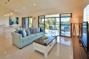 a living room with a couch and a table at Heliconia Grove - 1 bedroom - on Hamilton Island by HIHA in Hamilton Island