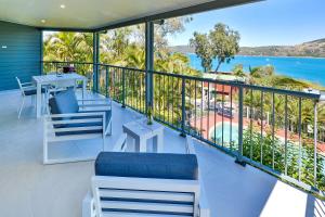 a balcony with chairs and a view of the ocean at Heliconia Grove - 1 bedroom - on Hamilton Island by HIHA in Hamilton Island