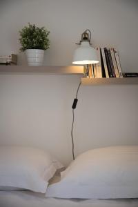 a lamp sitting on a shelf above a bed at Les Secrets de Sainte Eulalie - Première Conciergerie in Montpellier