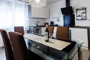 Una botella de vino sentada en una mesa de cristal en una cocina en Venami Holiday Home, en Jadranovo
