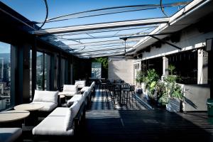 un patio con divani, tavoli e sedie in un edificio di Maxx Jeju, a member of H Rewards a Jeju