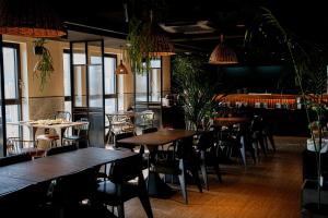 un ristorante con tavoli, sedie e piante in vaso di Maxx Jeju, a member of H Rewards a Jeju