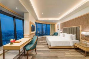 阿杰梅尔Sarovar Portico Ajmer的一间配有床、书桌和窗户的酒店房间
