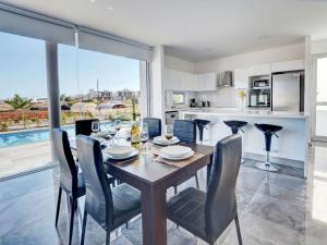 eine Küche und ein Esszimmer mit Tisch und Stühlen in der Unterkunft Villa Manta Chrysos - Brand New Luxury 3 Bedroom Protaras Villa in Protaras