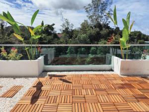 a balcony with a wooden floor and two plants at #MyLuxeGetaway,Quintet Cameron Highlands in Cameron Highlands