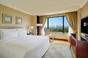 Postel nebo postele na pokoji v ubytování The Kunlun Beijing Jin Jiang Radisson