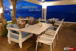 a restaurant with tables and chairs and a blue wall at Kekrifalia Hotel in Skala
