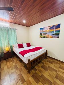 Un dormitorio con una cama con un cuadro en la pared. en River Raga Nature Resort, en Kārkāl