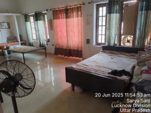 a bedroom with a bed and a fan and windows at Arvind maurya home stye in Naimishāranya