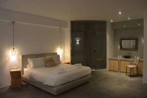 a bedroom with a large bed and a bathroom at Luxury Santorini Villa Villa Elysian Tessera Private Pool 1 Bedroom in Foinikiá