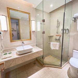 une salle de bain avec un lavabo et une douche en verre dans l'établissement Vienna Hotel Guangdong Maoming China 1st Beach, à Dianbai