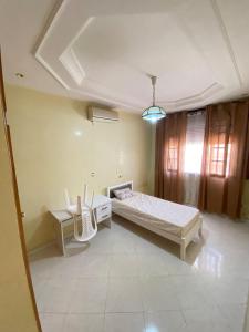 Un dormitorio con una cama y una mesa y sillas. en Apartment, Oujda, en Oujda