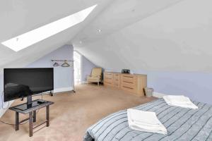 Un dormitorio con una cama y un televisor de pantalla plana. en Sea Downs House with Free Parking By My Getaways, en Peacehaven 35 fotos más