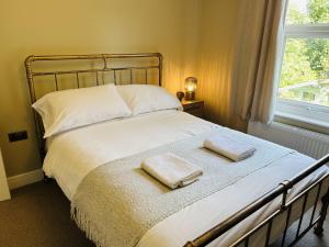 a bedroom with a bed with two towels on it at Oyster Stay House By My Getaways in Whitstable