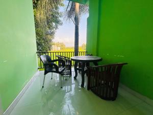 a table and chairs on a balcony with a palm tree at Ancient Village in Polonnaruwa +13 photos