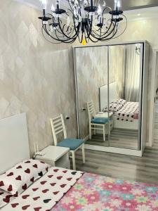 タシュケントにあるCozy New Apartment in a Quite Neighborhoodのベッドルーム1室(ベッド1台、椅子2脚、シャンデリア付)