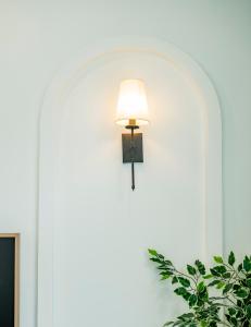 a light on a white wall with a lamp on it at Biệt thự sân vườn sang trọng Hayha Villa - Tropical Garden Khem Beach in Phu Quoc