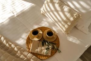 a bed with two coffee mugs on a table at Zandore Villas Perdika private Luxury Villas Epirus Villas in Pérdika +54 photos