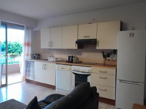a kitchen with white cabinets and a couch in a room at ZenGarden Pool,3bedrooms,lit bébé Beach800m,box&wifi in Antibes